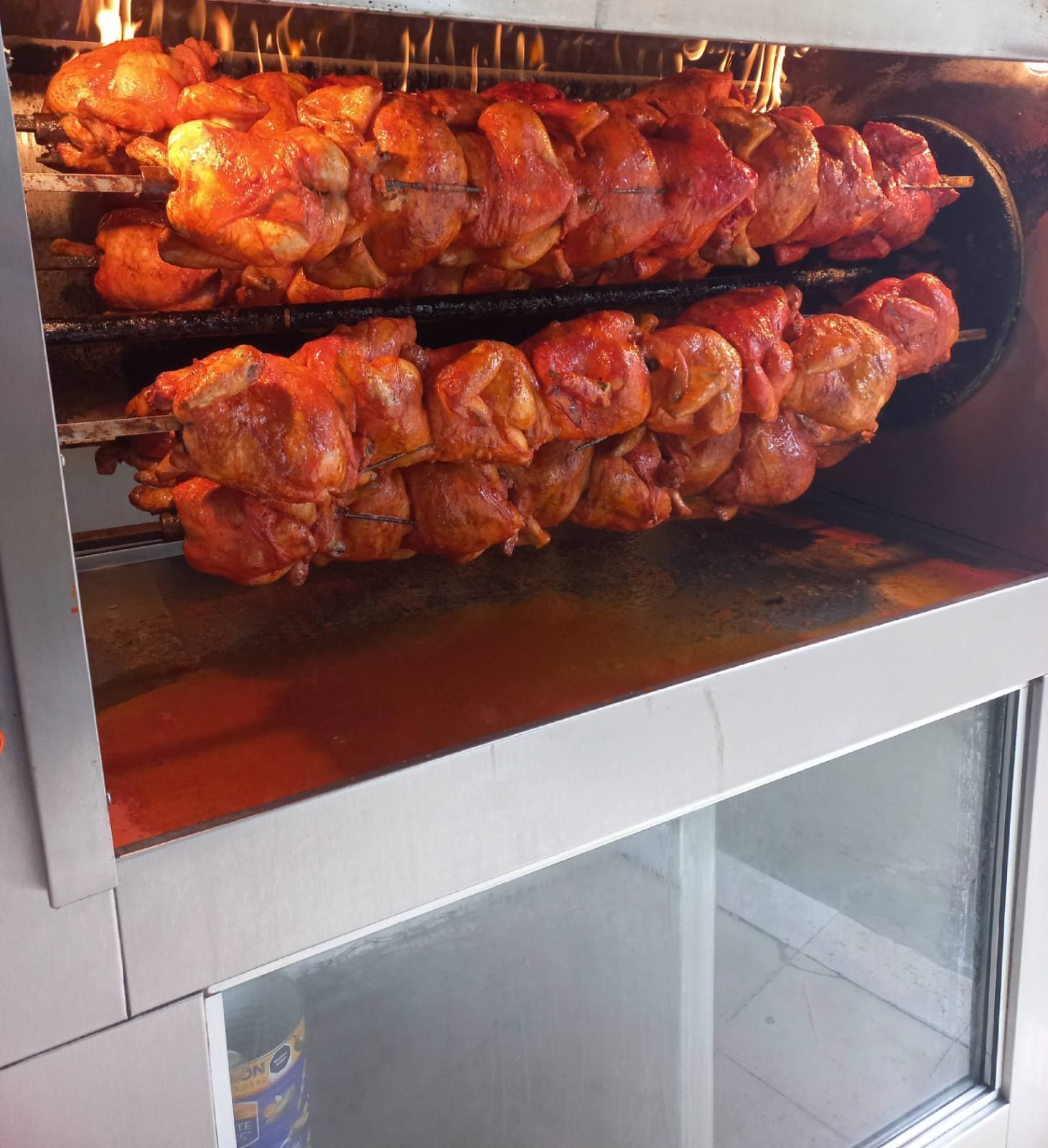 Pollos rostizándose en el asador de Pollo Riko